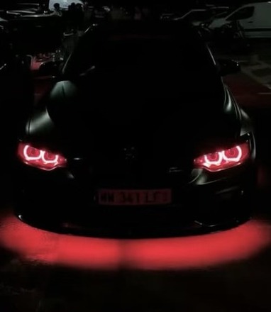 La BMW M3 F80 noire de nuit, feux rouges allumés et LED rouges sous la caisse
