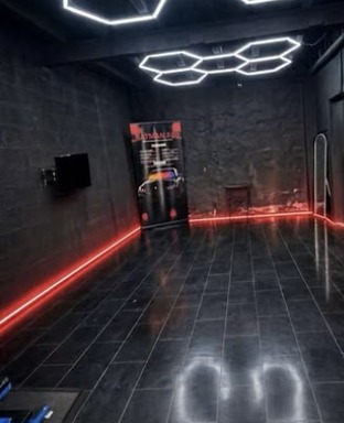 L'atelier : sol carrelé noir, néons rouges au sol et plafonnier LED hexagonal